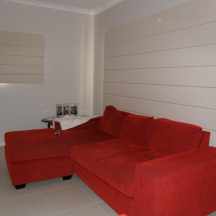 Block out Roman Blinds in closed down position in lounge room area with red colour couch and grey carpet in Melbourne Victoria 3000