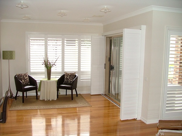 Scratch Proof White PVC Plantation Shutters Melbourne installed in Living room with pollished timber floors