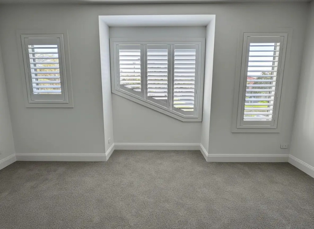 Custom-shaped plantation shutters on angled windows Melbourne - Into Blinds